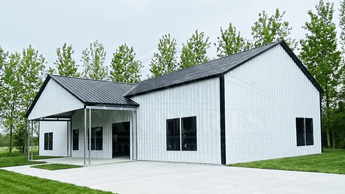 Two-tone tan and black barndominium with vertical roof, dual roll-up garage doors, and side lean-to — Get Carports